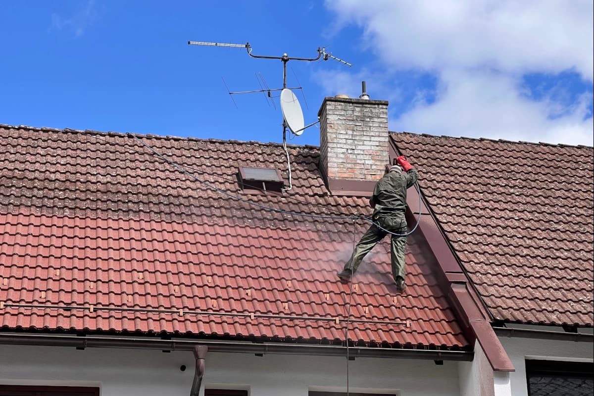 Betonová střecha pokrytá mechem a lišejníky před vysokotlakým čištěním